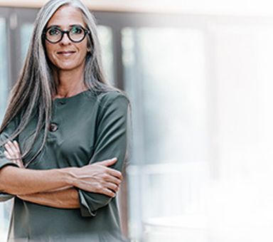 Woman standing with arms crossed in an office