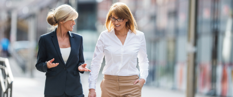 Two businesswomen walking and talking outside