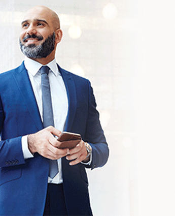 Man standing in an office holding a phone