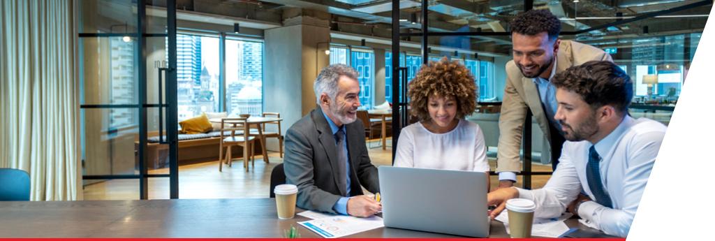Colleagues working around a computer in an office