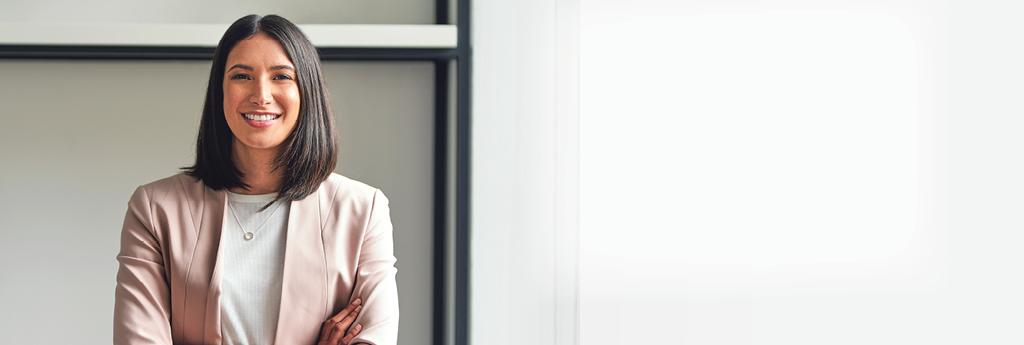 Woman standing in an office with her arms crossed
