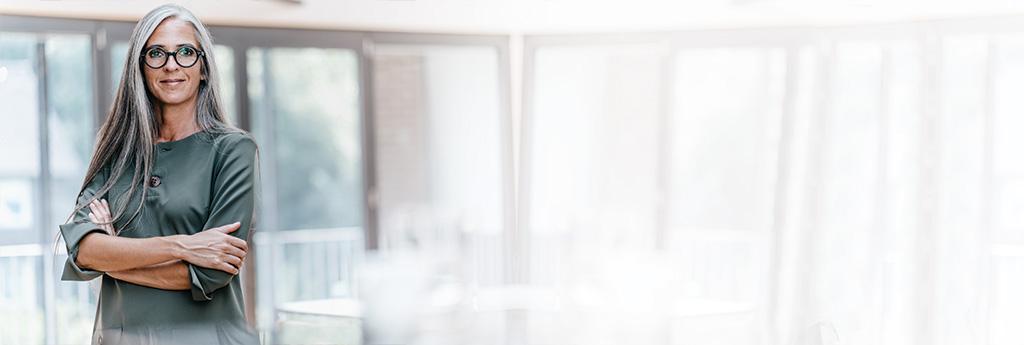 Woman standing in an office with arms crossed